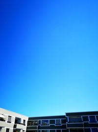 Low angle view of buildings against clear blue sky