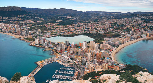 High angle view of illuminated city by sea