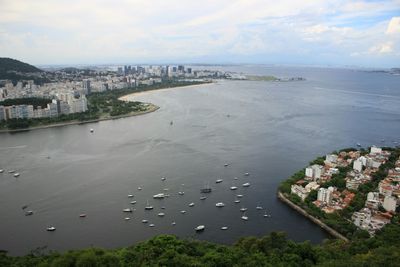 High angle view of town by sea against sky