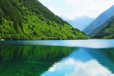 Scenic view of lake by mountains against sky