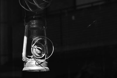 Close-up of oil lamp hanging in darkroom