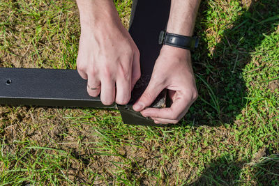 Worker with a hand tool assembling metal construction outdoors