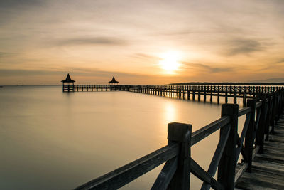 Pier over sea against sky during sunset