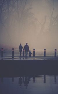 Rear view of family on wet street during foggy weather