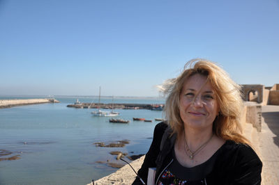 Portrait of woman with old port in background