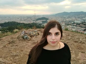 Portrait of beautiful young woman against sky