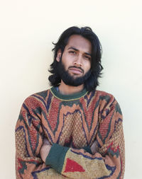 Portrait of young man standing against white background