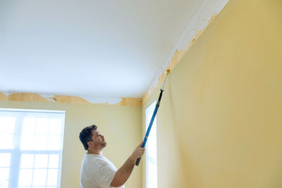 Man removing paint at home