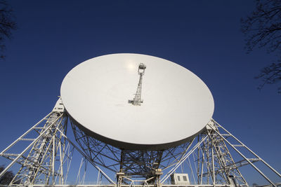 Low angle view of communications tower against clear blue sky