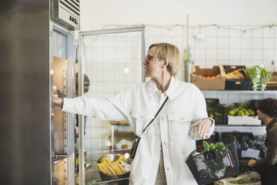 Blond mature woman buying food from store