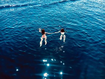 High angle view of couple swimming in sea
