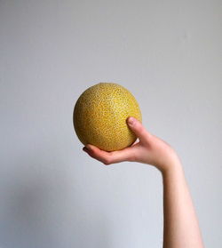 Cropped image of hand holding knife over white background