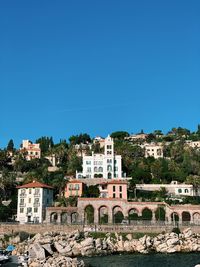 Buildings in town against clear blue sky