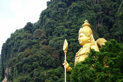 Statue against trees and sky