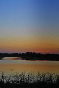 Scenic view of lake against sky during sunset