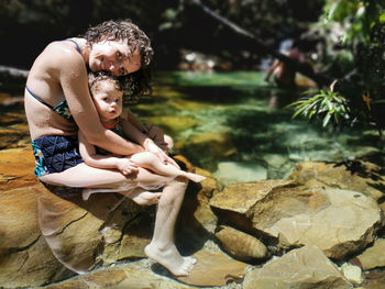 Full length of woman sitting on rock