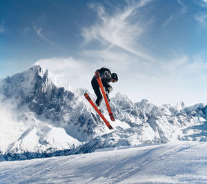 Person skiing on snowcapped mountain against sky