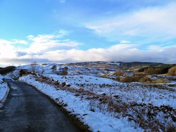 Snow covered land against sky