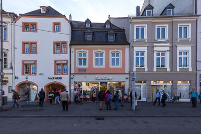 People walking on street against buildings in city