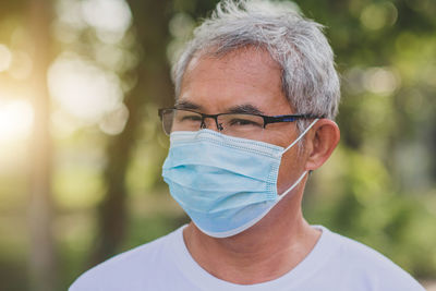 Close-up portrait of man wearing eyeglasses outdoors