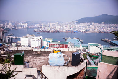 High angle view of cityscape at waterfront during sunny day
