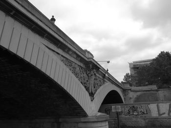 Low angle view of bridge against cloudy sky