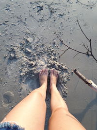 Low section of woman standing on wet beach