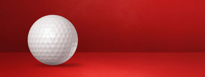 Close-up of ball on table against red background