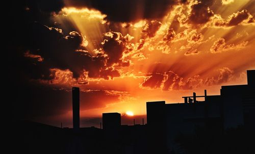 Silhouette buildings against sky during sunset