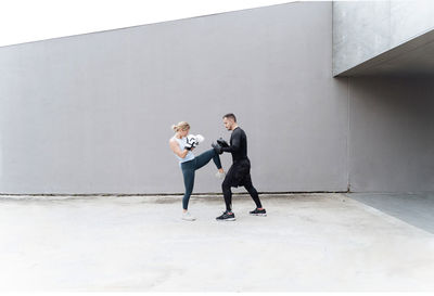 Young couple standing against wall