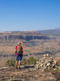 Rear view of man standing on rock