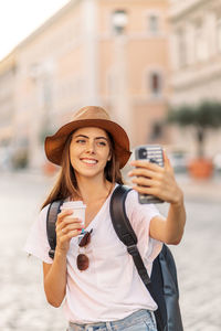 Young woman using mobile phone while standing outdoors