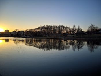 Scenic view of lake against clear sky during sunset