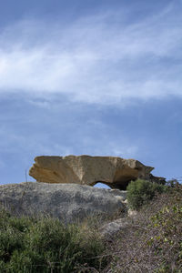 Rock formation on field against sky