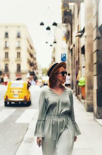 Young woman standing on street in city