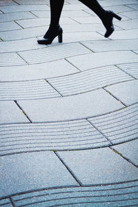 Low section of woman walking on zebra crossing