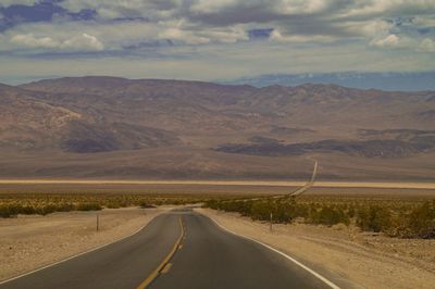 Empty road along landscape and mountains