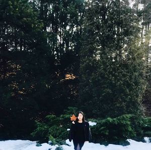 Portrait of woman standing by tree