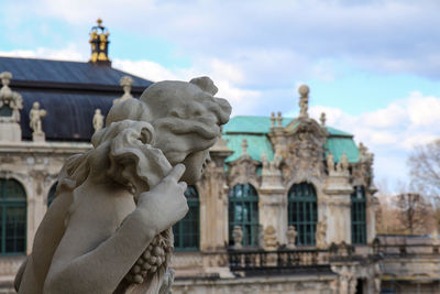 Statue of historic building against cloudy sky