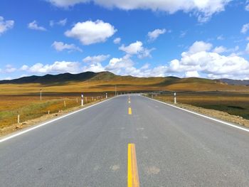 Empty road along countryside landscape