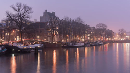 Boats moored in river at night