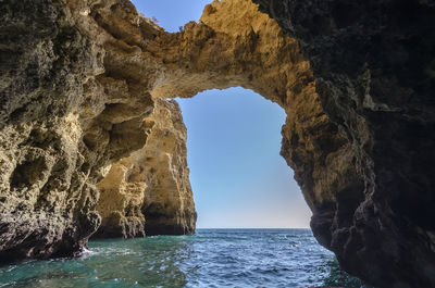 Rock formations by sea against sky