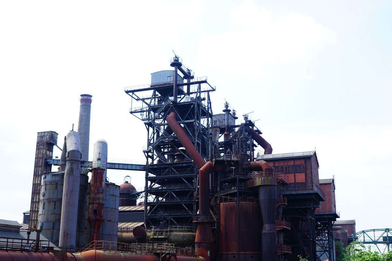 LOW ANGLE VIEW OF CRANE AT FACTORY AGAINST SKY