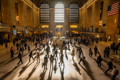 High angle view of people walking on floor at railroad station