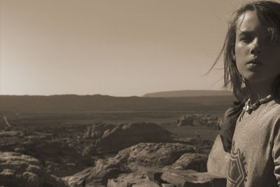 Portrait of boy in desert against clear sky