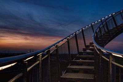 Low angle view of footbridge against sky at sunset