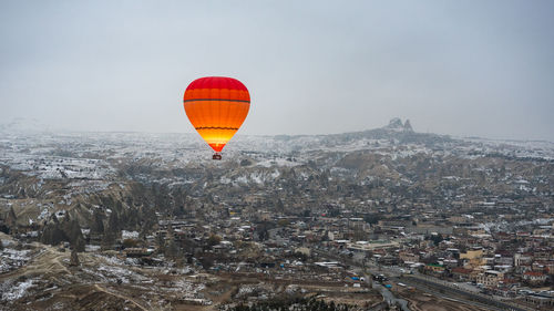 Hot air balloon flying over city