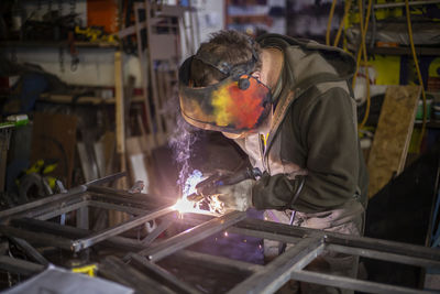 Man welding metal in workshop