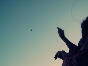 Low angle view of bird flying against blue sky