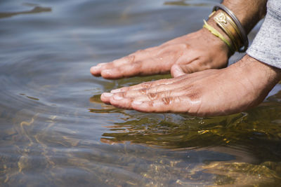 Cropped image of hands over lake